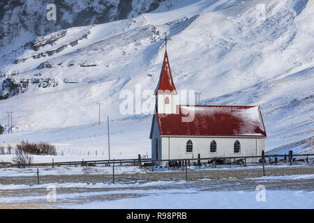 Chiesa Reyniskirkja nelle montagne innevate vicino a Vik e Reyniskirkja Beach, in inverno in Islanda Foto Stock