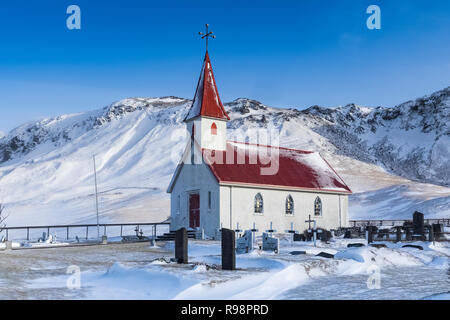 Chiesa Reyniskirkja nelle montagne innevate vicino a Vik e Reyniskirkja Beach, in inverno in Islanda Foto Stock