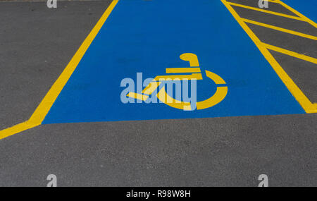 Disabilità parcheggi segnalati in standard internazionale insegne luminose blu e giallo. Foto Stock