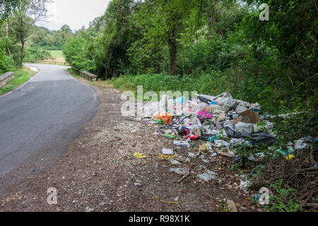 Roma, Italia - 21 Giugno 2018: rifiuti abbandonati nella campagna vicino alla strada Foto Stock