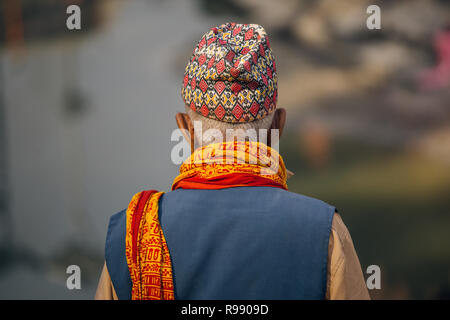 Vista posteriore del uomo nepalese in abiti tradizionali da torna a Pashupatinath, Kathmandu Foto Stock