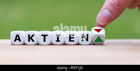 È a mano ruotando un dado e cambia la direzione di una freccia che simboleggia che il valore delle scorte ("Aktien' in tedesco) sta in alto (o viceversa) Foto Stock