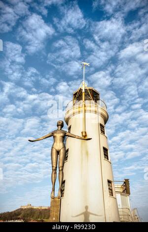 Il faro a Scarborough con un memoriale di figura con le braccia tese davanti. Vi è un cielo blu il sovraccarico con la rottura cloud. Foto Stock
