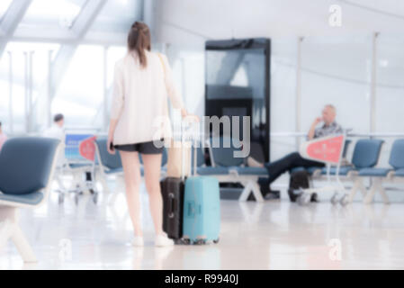 Immagine sfocata di viaggiatori con bagaglio al Terminal di partenza in aeroporto. Foto Stock