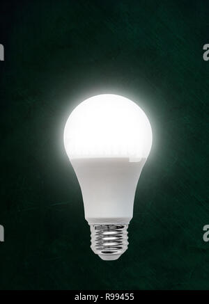 Illuminata efficiente dal punto di vista energetico Diodo emettitore di luce LED lampadina isolati su lavagna sfondo con copia spazio. Foto Stock