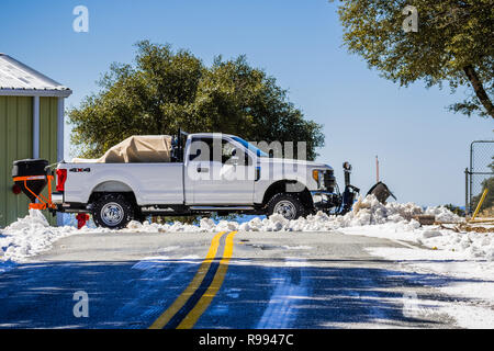 Febbraio 27, 2018 San Jose / CA / STATI UNITI D'AMERICA - Carrello equipaggiato con un aratro lo sgombero neve dalla strada sulla cima di Mt Hamilton su una mattina di sole, South San Foto Stock