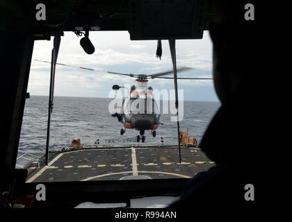 L'equipaggio del guardacoste Munro (WMSL 755) conduce operazioni aeree con una stazione di aria Barbieri punto HM-65 Delfino elicottero equipaggio nel Pacifico centrale, nov. 28, 2018. La Munro era sul suo primo pattuglia operativa ed era far rispettare le misure di conservazione e di gestione stabilite dal Pacifico occidentale e centrale della Commissione per la pesca. (U.S. Coast Guard foto di Sottufficiali di terza classe Matteo West/rilasciato) Foto Stock