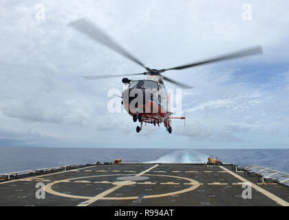 L'equipaggio del guardacoste Munro (WMSL 755) conduce operazioni aeree con una stazione di aria Barbieri punto HM-65 Delfino elicottero equipaggio nel Pacifico centrale, nov. 30, 2018. La Munro era partecipare alla sua prima pattuglia operativa in cui esso applicate le misure di conservazione e di gestione stabilite dal Pacifico occidentale e centrale della Commissione per la pesca. (U.S. Coast Guard foto di Sottufficiali di terza classe Matteo West/rilasciato) Foto Stock