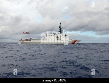 Il Guardacoste Munro (WMSL 755) equipaggio conduce operazioni di aria con una stazione di aria Barbieri punto HM-65 Delfino elicottero equipaggio mentre di pattuglia nel Pacifico centrale, Dicembre 4, 2018. La taglierina è stata in rotta per le isole Figi dopo la visita di Honiara su Guadalcanal, isole Salomone. (U.S. Coast Guard foto di Sottufficiali di terza classe Matteo West/rilasciato) Foto Stock