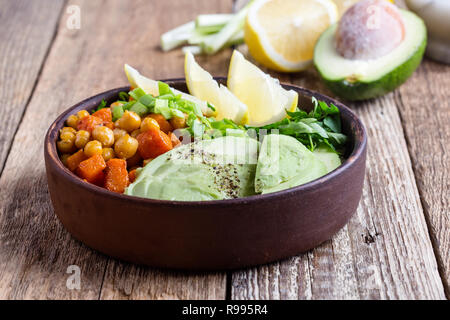 Un sano di ceci quinoa avocado ciotola su tavola in legno rustico, vegetale, alimentare il fuoco selettivo Foto Stock