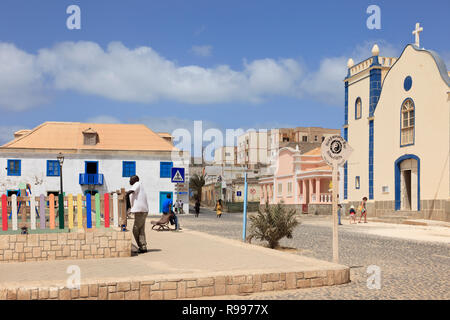 Scena nella piazza principale con la strada di ciottoli e la Chiesa cattolica di San Isobel. Largo Santa Isobel, Sal Rei, Boa Vista, Isole di Capo Verde, Africa Foto Stock