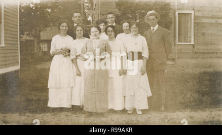 Antique c1910 fotografia, gruppo di uomini e donne posano per una foto vicino a loro granaio. Posizione sconosciuta, STATI UNITI D'AMERICA. Fonte: fotografia originale Foto Stock