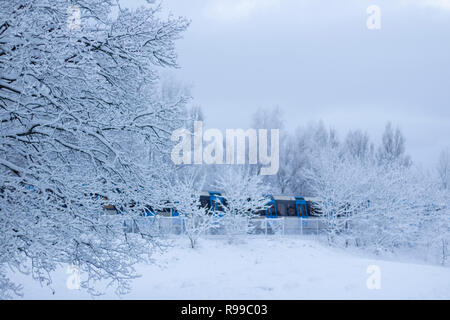 Wintery paesaggio con neve soffice e treni pendolari accelerando da, a Stoccolma, in Svezia. Foto Stock