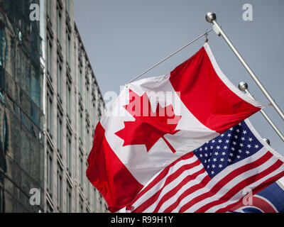 Canada e Stati Uniti d'America le bandiere di fronte ad un edificio aziendale in Toronto Ontario, Canada. Toronto è la più grande città del Canada e uno dei principali attori economici Foto Stock