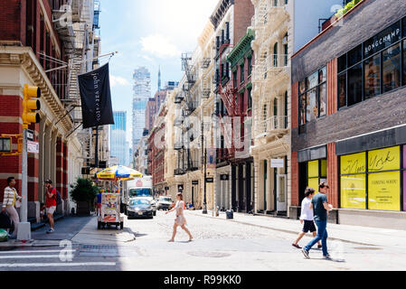 La città di New York, Stati Uniti d'America - 25 Giugno 2018: persone attraversando Greene Street con lusso fashion store sullo sfondo di Soho in ghisa quartiere storico Foto Stock