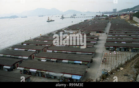 Anni '70, vista dall'alto attraverso una fila di unità di stoccaggio a un piano situato lungo la riva del porto di Hong Kong dal Mar Cinese Meridionale. Foto Stock