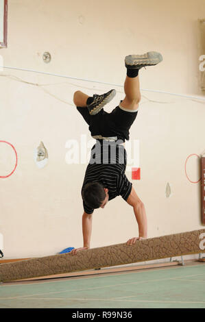 Kovrov, Russia. Il 13 ottobre 2013. Teen facendo handstand in palestra Foto Stock