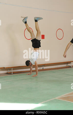 Kovrov, Russia. Il 13 ottobre 2013. Teen facendo handstand in palestra Foto Stock