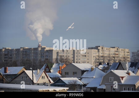 Kovrov, Russia. Il 26 gennaio 2014. Radio-controllato modello di polistirolo aereo in volo contro un paesaggio urbano Foto Stock