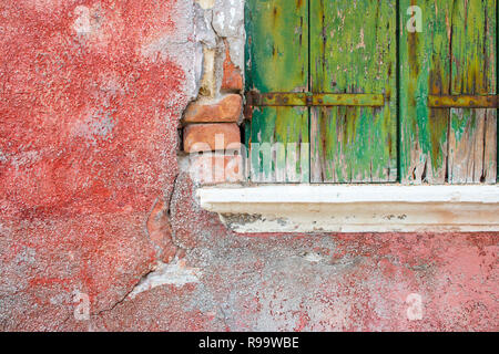 Dettaglio ravvicinato della vernice sbiadita sulle vecchie persiane delle case colorate di Burano Venezia Italia Foto Stock
