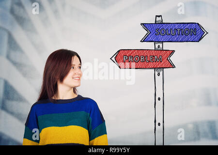 Giovane donna guardando un cartello stradale disegno con una soluzione e il problema delle frecce che indicano a destra e sinistra. Scelta di vita, sfida e concetto di decisione Foto Stock