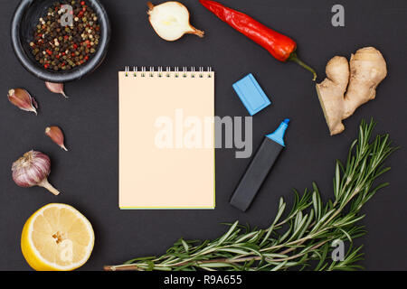 Gli ingredienti con copia spazio per ricetta di cucina. Radice di Zenzero, peperoncino, aglio, cipolla, limone, il pepe della Giamaica peperoni in recipiente di vetro e rosmarino bla Foto Stock