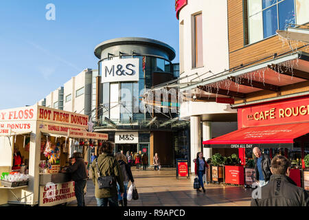 Westwood Cross Shopping Centre, Inghilterra. Super sabato. M&S store e Cafe Rouge ingresso con ciambella in stallo. Persone in cappotti. L'inverno. Sunshine. Ultimo sabato prima di Natale, scarsa affluenza alle urne e poco interesse in quali negozi sono in vendita. Foto Stock