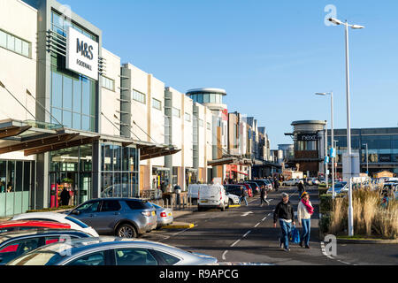 Westwood Cross Shopping Centre, Inghilterra. Parcheggio auto pranzo con vetture, M&S entrata dello store e visualizzare lungo il centro commerciale per lo shopping. Cielo blu chiaro. Super sabato. Foto Stock