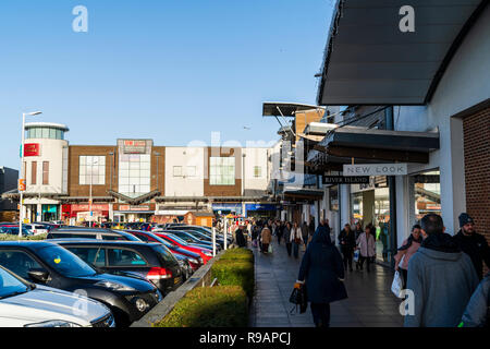 Westwood Cross Shopping Mall, super sabato. Pochi gli amanti dello shopping a piedi lungo passato negozi, scarse vendite per i negozi su ultimo fine settimana prima di Natale. Vista lungo la fila di negozi di marca, con gente camminare lungo e automobili parcheggiate. Foto Stock