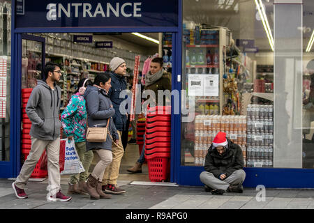 Southport Town Center, Merseyside, Regno Unito. 22nd dicembre 2018. Persone che passano senza tetto uomo raggedly, indossando Natale Babbo Natale cappello rosso a Natale. Credit: Mediaworldimages/Alamy Live News Foto Stock