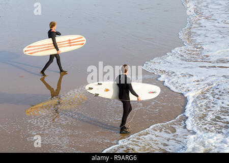 Bournemouth Dorset, Regno Unito. Il 22 dicembre 2018. I visitatori godere il sole a Bournemouth spiagge - surfers testa per il mare mantenendo le loro tavole da surf. Credito: Carolyn Jenkins/Alamy Live News Foto Stock