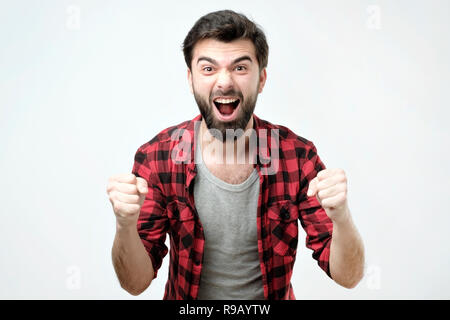 Ritratto di felice uomo spagnolo con i pugni fino per celebrare la sua vittoria Foto Stock