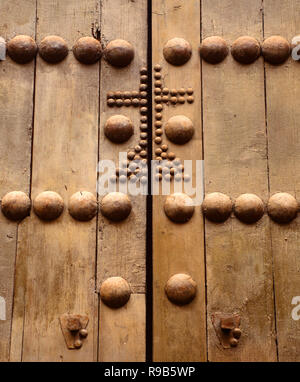 Cordoba, Spagna. Medievale, studded porta in legno con il simbolo della croce Foto Stock