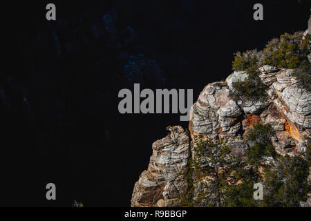 Cliff bordo contro un canyon scuro muro Foto Stock