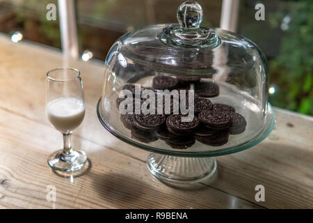 Late Night Oreo Cookie servita accanto a un bicchiere di latte Foto Stock