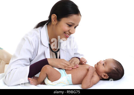 Allegro femmina trattiene pediatra neonato Foto Stock