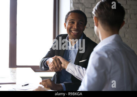 Soddisfatto client nero agitando mani ringraziando manager per buona d Foto Stock