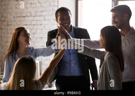 Emozionato multirazziale team dare alta cinque, teambuilding concept Foto Stock
