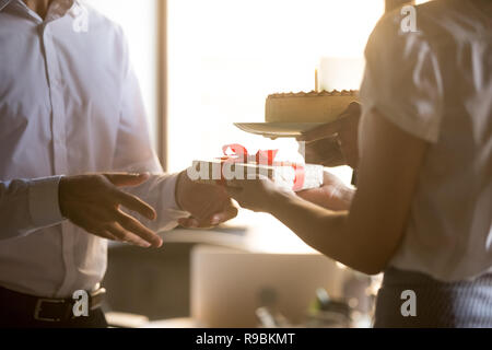 I colleghi congratulandomi con un collega la ricezione di confezione regalo e birthd Foto Stock