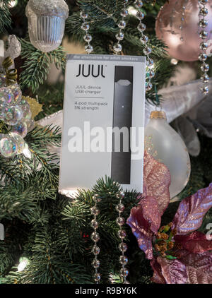 Casella azienda JUUL dispensatore di nicotina e baccelli su albero di Natale Foto Stock