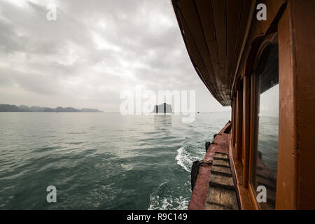 Un turista in barca a vela è sull'acqua della baia di Ha Long in Vietnam. Foto Stock