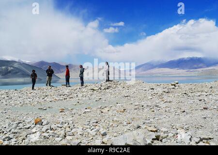 Turisti viaggiano lungo la Karakoram Highway nello Xinjiang Uyghur Regione autonoma, Cina, con lo splendido paesaggio di montagna della Valle dello sfondo. Foto Stock