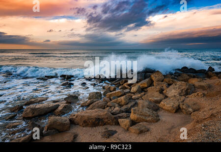 Riva del mare con scogliere, onde che si infrangono sulle rocce Foto Stock