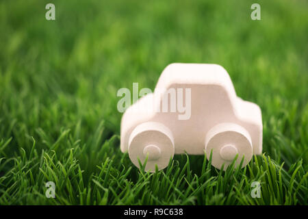 Auto giocattolo sul prato verde. Guida Ecologica concetto Foto Stock