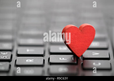 Piccolo cuore rosso sulla tastiera. Internet Dating concetto. Foto Stock