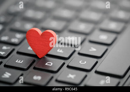 Piccolo cuore rosso sulla tastiera. Internet Dating concetto. Foto Stock