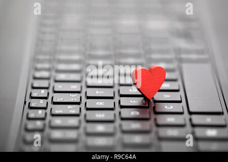 Piccolo cuore rosso sulla tastiera. Internet Dating concetto. Foto Stock