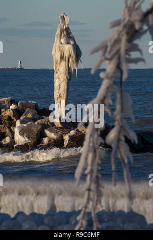 Rivestimento di ghiaccio un faro del porto dopo una tempesta di neve sul Lago Michigan nel Merlano, Indiana. Foto Stock