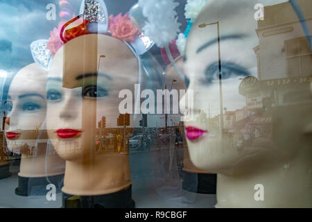 Teste di manichino in vetrina, manichini in una fila con la riflessione sul lungomare Foto Stock