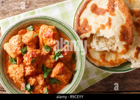 Karhai indiano pollo in salsa piccante di close-up servite con pane naan sul tavolo. parte superiore orizzontale vista da sopra Foto Stock